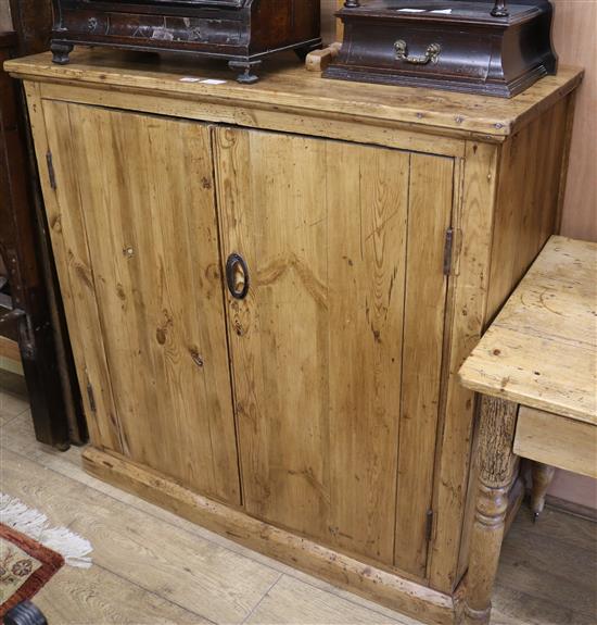 A plain stripped pine two door cupboard W.106cm